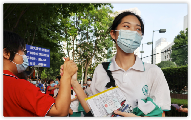 12 2021年6月7日，广州，华南师范大学附属中学高考考点，来自113中学的老师在考场入口前给学生打气。.png