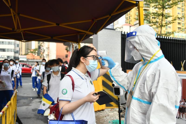 9 【市一中考点】 来自中风险地区的考生，测量体温、洗手消毒、更换口罩，进入考场（记者 李波 何钻莹 张晓宜）.png