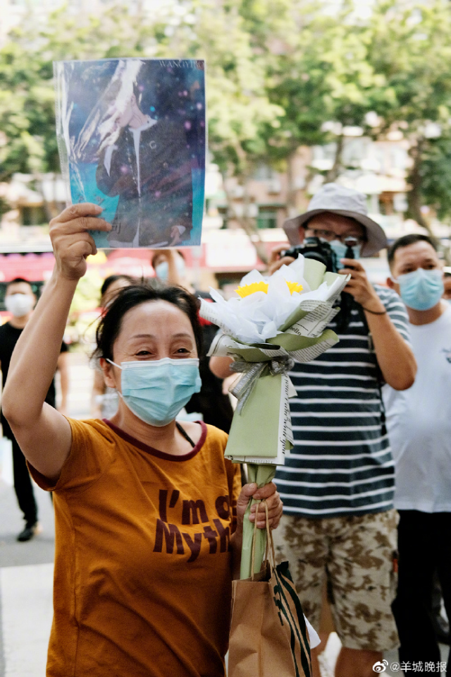 28 广州市第六中学考场,一位考生的妈妈高举女儿的偶像照片，迎接高考结束的女儿。.jpg